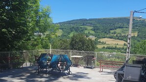 A fenced outdoor area with seating and a view of rolling hills.