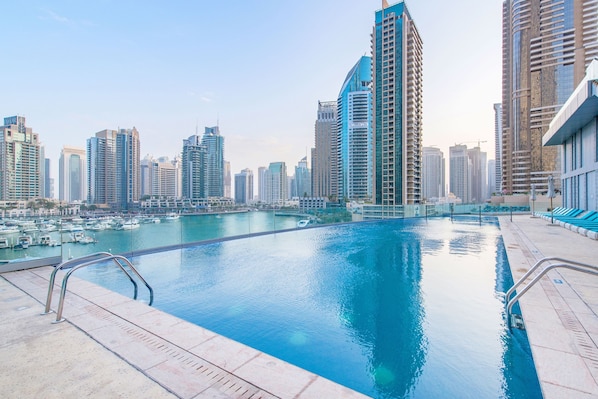 A swimming pool with a cityscape view, surrounded by high-rise buildings.