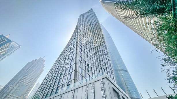 A tall, modern skyscraper with a grid-like facade and reflective glass windows. - Iconic Marina Stay Cayan Tower 2BR (Dubai)