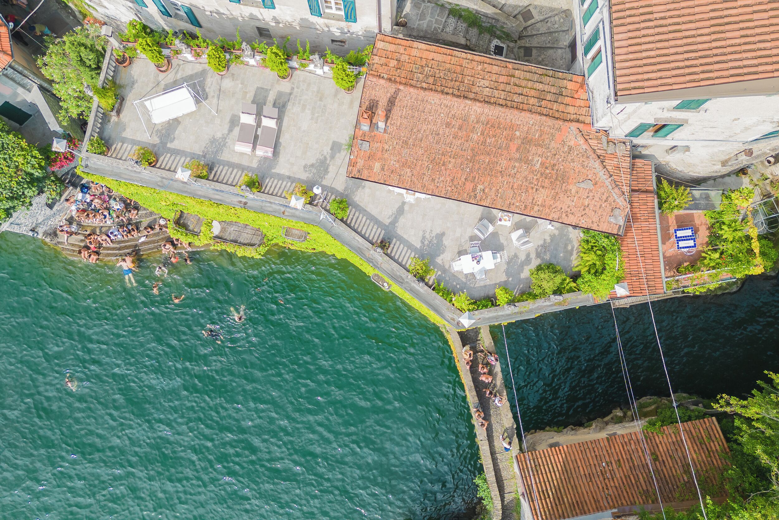 Luchtbeeld van een watergebied met gebouwen, een zwemgedeelte en een verharde promenade.