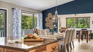 A modern kitchen with a granite countertop, wooden cabinets, and a dining area with a table and chairs.
