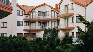 Un edificio residenziale a più piani con balconi, ampie finestre e tetto in tegole.