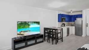 A modern kitchen with blue cabinets, a built-in microwave, and a stainless steel refrigerator. - Ocean Dr 1BR Miami Beach Getaway (Miami Beach)