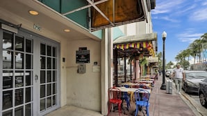 A street-side restaurant with outdoor seating, a signboard, and a number 710 on the building. - Ocean Dr 1BR Miami Beach Getaway (Miami Beach)