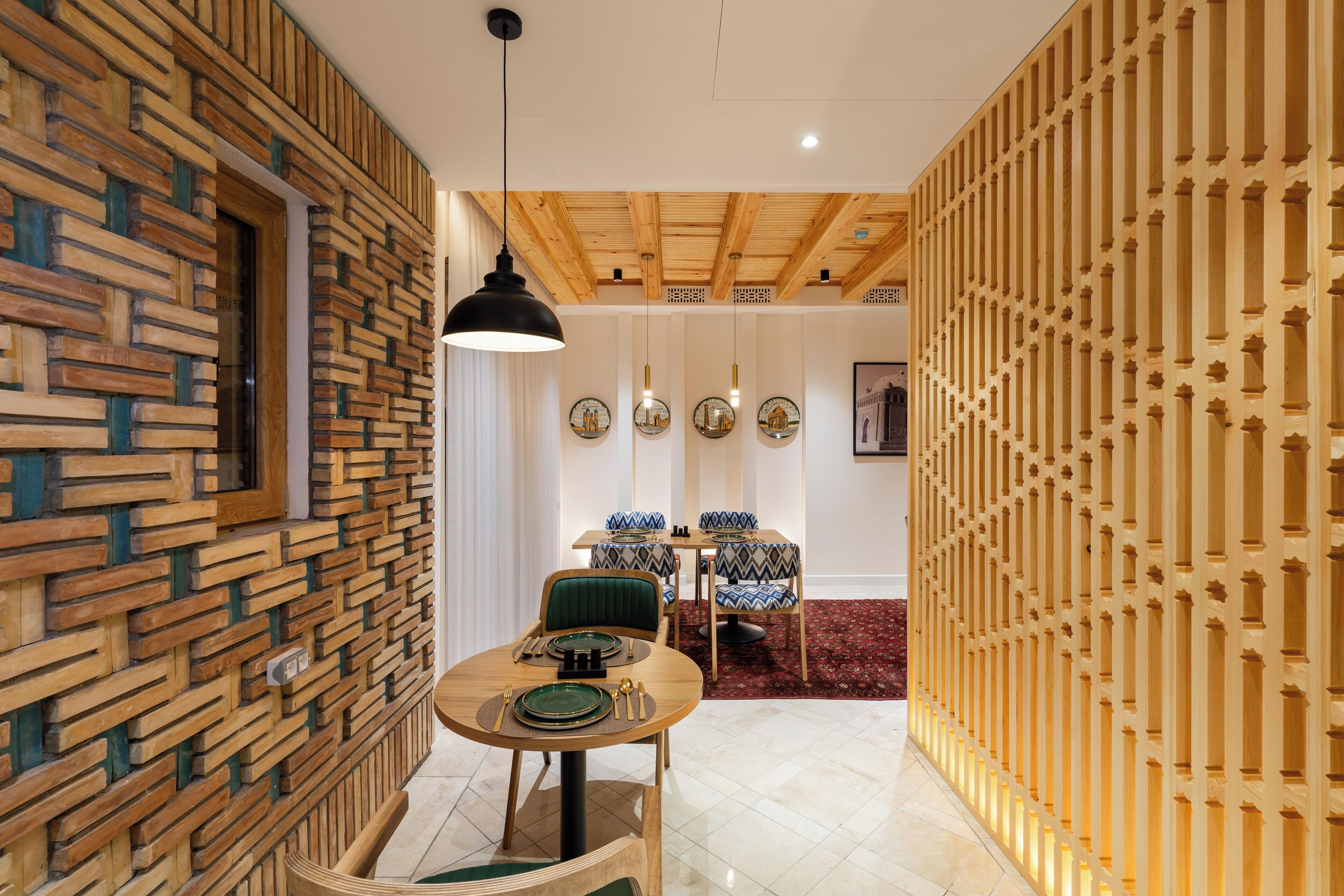 Un espace repas avec un mur en bois, une table ronde et des chaises.