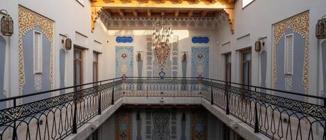 Un patio con barandillas ornamentales y un candelabro en el centro.