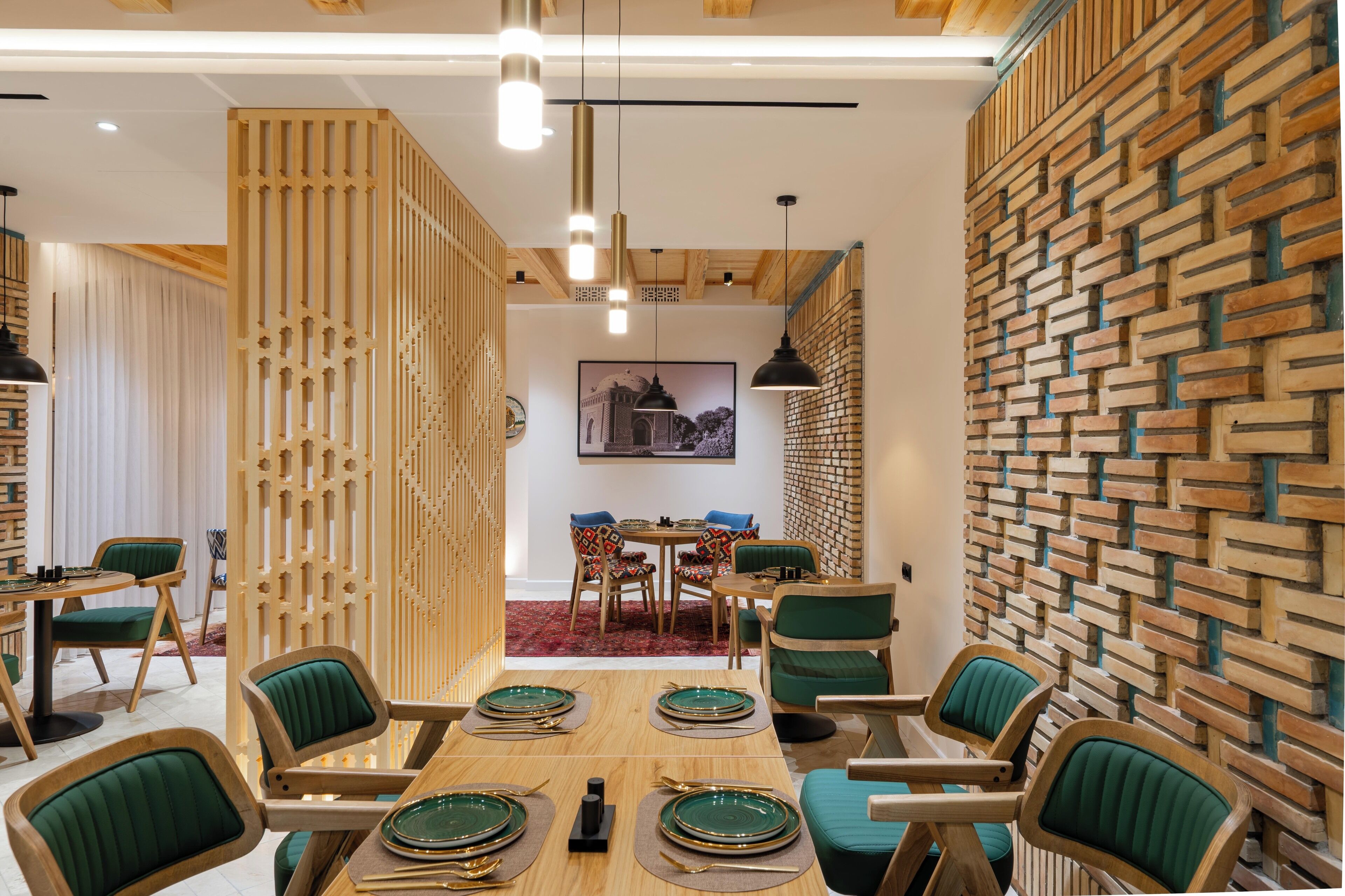 A dining area with a wooden table set for six, surrounded by green upholstered chairs.