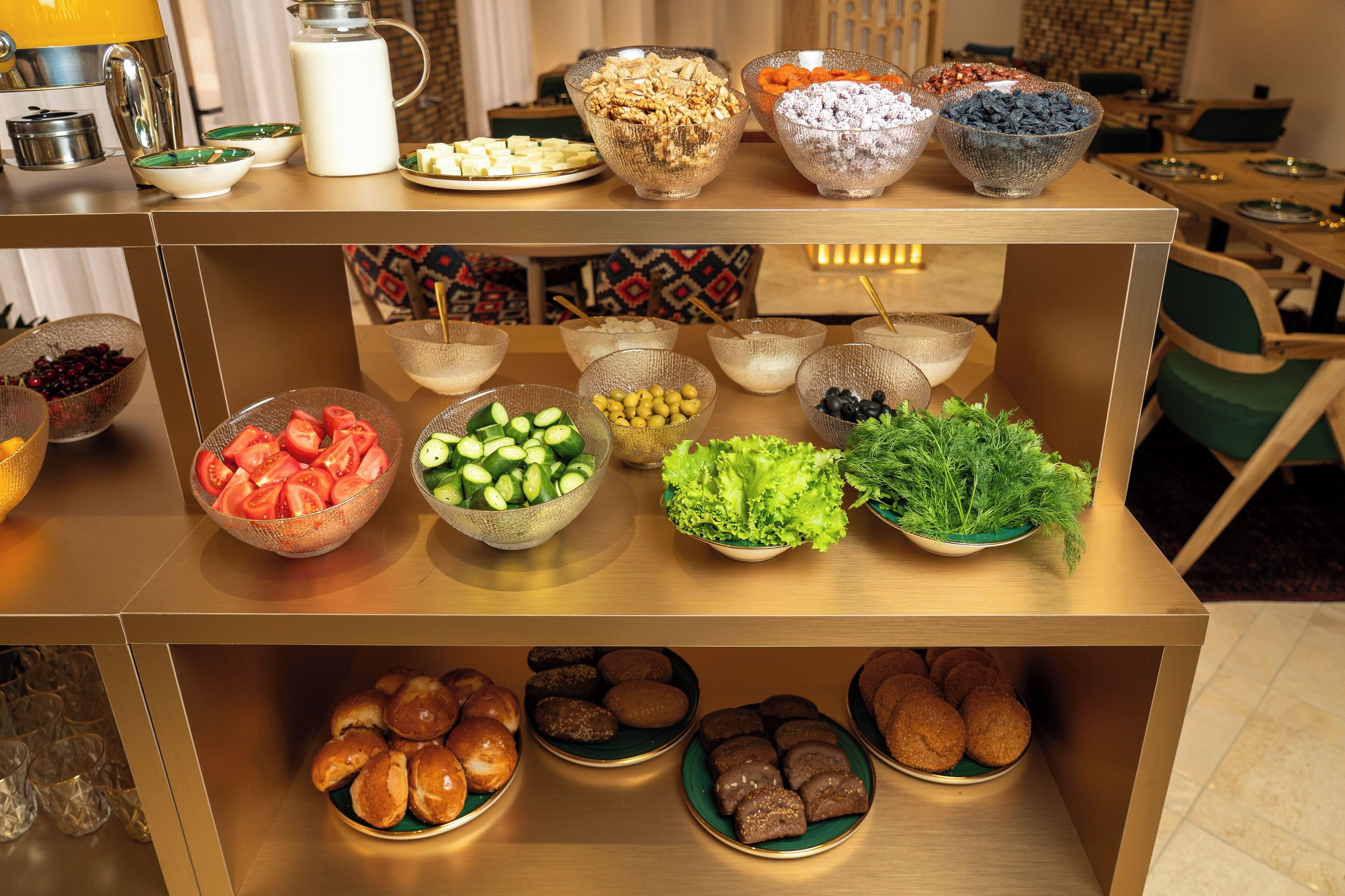 A buffet table with various food items including fruits, vegetables, and pastries.