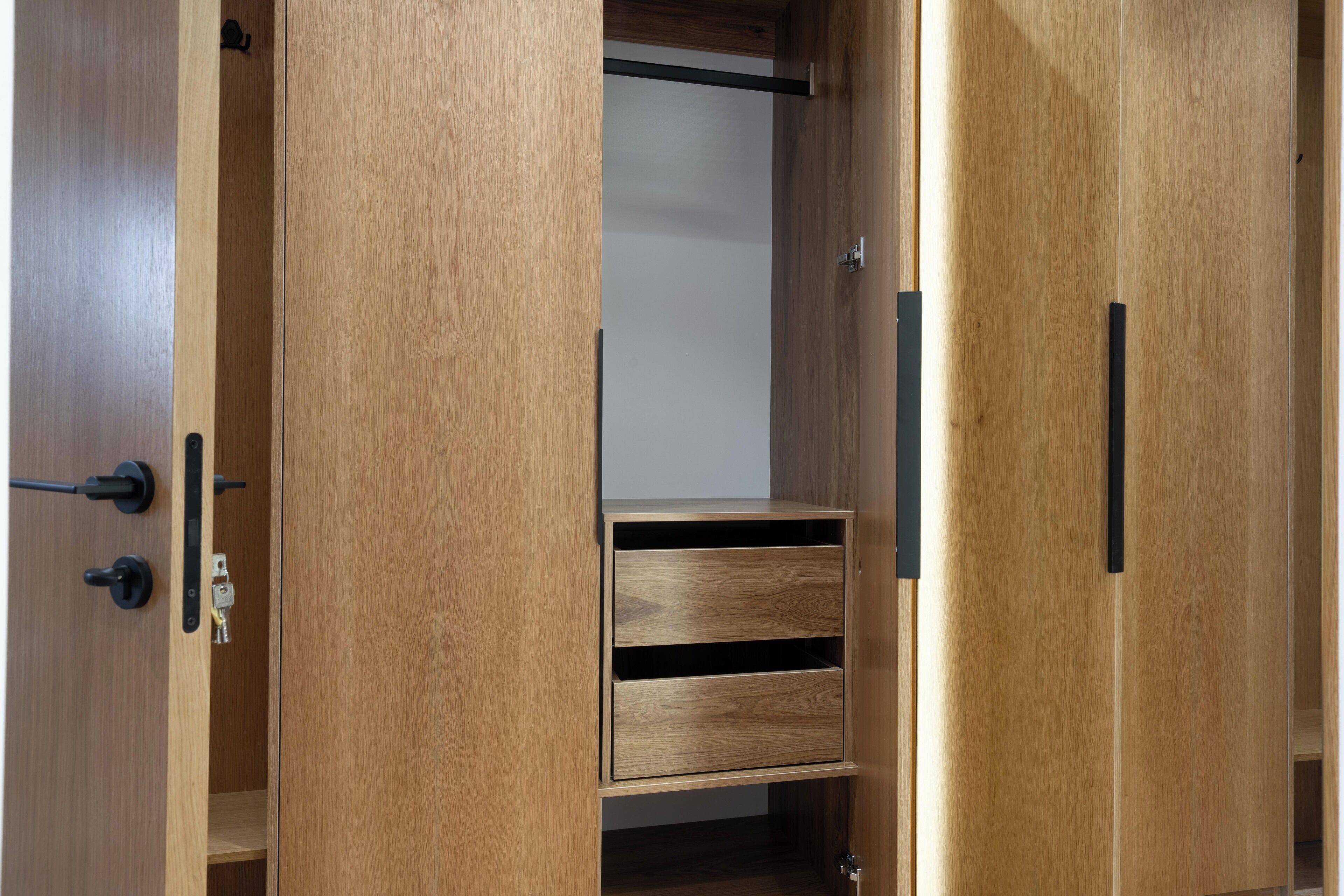A wooden wardrobe with a sliding door, a small shelf, and a drawer.
