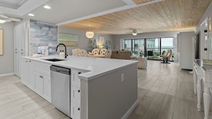 A spacious kitchen with a central island, white cabinetry, and a dishwasher.