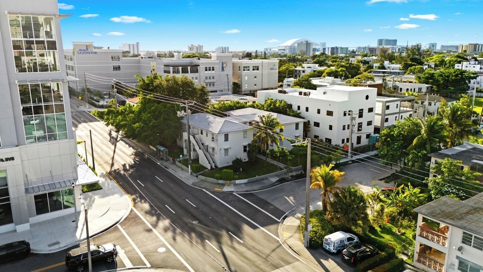 Un quartier urbain moderne qui présente un mélange de bâtiments résidentiels et commerciaux, dont un imposant bâtiment blanc sur lequel on peut lire l’inscription « Phare ».