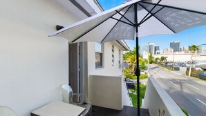 A balcony with a table and chairs, a large umbrella, and a city view. - Pet-friendly Brickell Stay Near Beach & City (Miami)