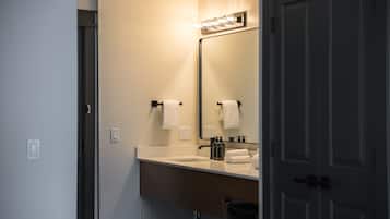 Une salle de bain équipée d’un lavabo, d’un miroir et d’un porte-serviettes.
