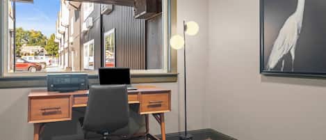 A room with a desk, chair, and a large window.