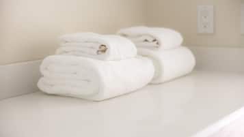 A stack of white towels on a white countertop.