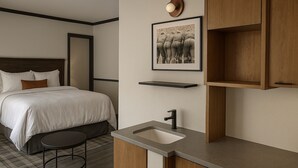 Ein Hotelzimmer mit Bett, rundem Tisch, Waschbecken und Schrank.