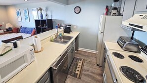 A compact kitchen with a microwave, sink, stove, and refrigerator. - Beachfront Condo with Amazing Ocean Views  4th Fl (Old Orchard Beach)