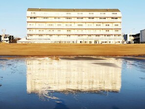 Um edifício com vários andares, teto plano e uma série de varandas.