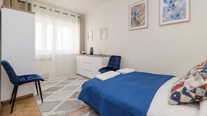 A bedroom with a bed, a desk, a chair, and a wardrobe. - ShortStayPoland Nowolipie B182 (Warsaw)
