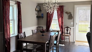 A dining room with a wooden table and chairs, a chandelier, and a sign indicating a pediatric waiting room.