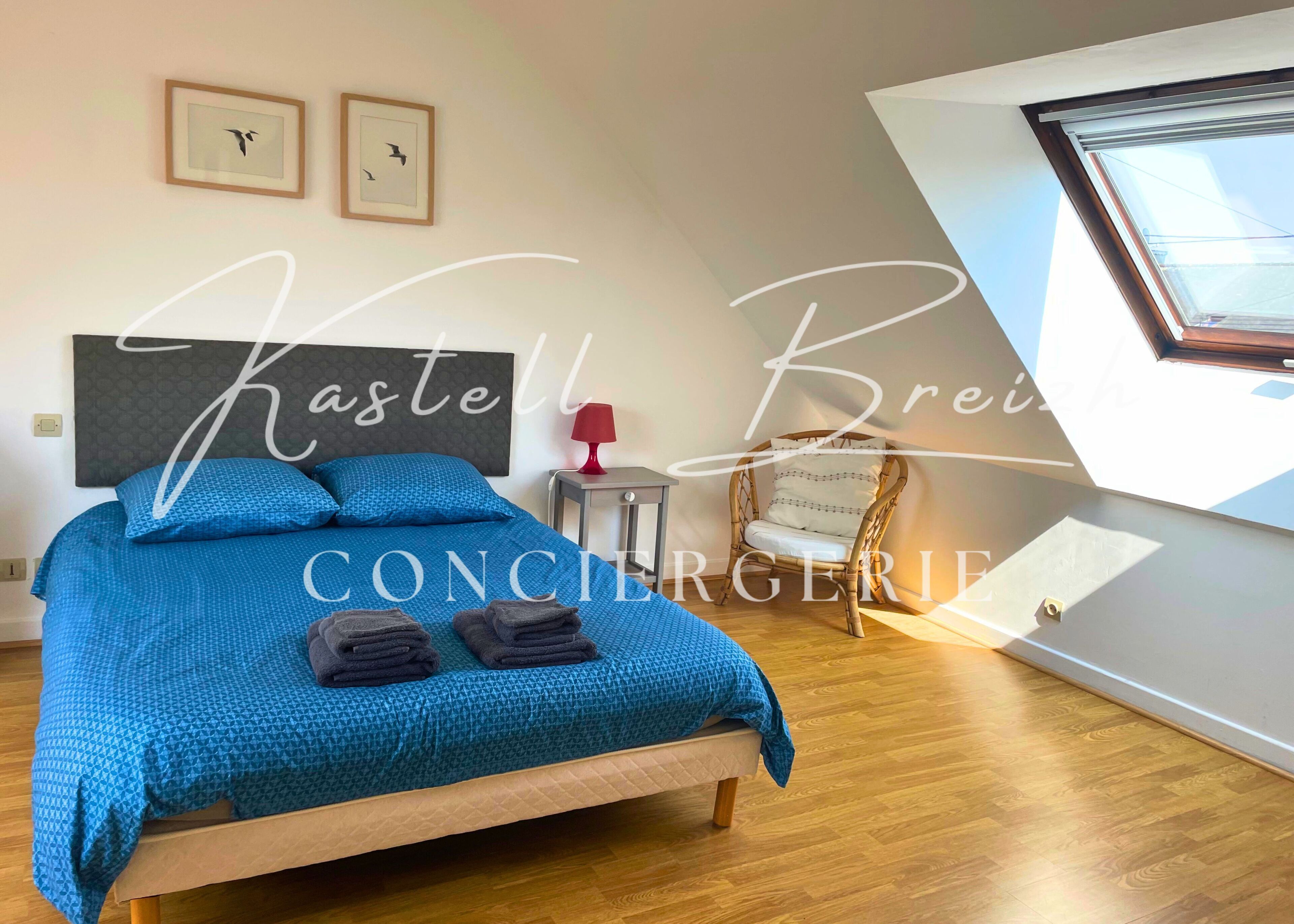 Un dormitorio con cama, una silla, una lámpara y una ventana.
