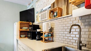 A kitchen with a built-in microwave, coffee maker, and a stainless steel sink. - Hollywood 1BR Near Beach & Dining (Hollywood)