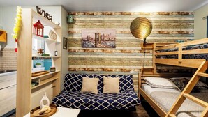 A cozy room with a wooden bunk bed, a sofa bed, and a wall decorated with a cityscape painting. - Hollywood 1BR Near Beach & Dining (Hollywood)