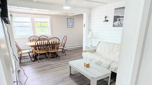 A spacious living room with a dining area, a white sofa, and a coffee table.