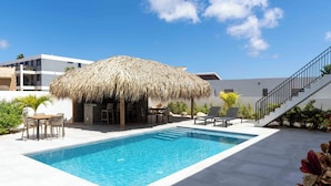 A swimming pool with a thatched roof structure, a staircase, and outdoor furniture. - Villa Valena 4 Centrally located, beach, restaurant and promenade within walking distance (Kralendijk)