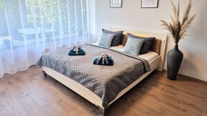 A neatly made bed with a quilted cover, two pillows, and a bedside vase. - Meerzeit apartment with terrace & parking space (Scharbeutz)