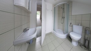 A bathroom with a sink, toilet, and shower.