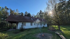 A house with a tiled roof, a wooden deck, and a fire pit in the yard.