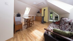 A loft-style living space with a dining area, kitchen, and a sofa.