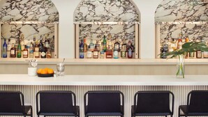 A bar area with three arched marble backdrops, black bar stools, and a variety of bottles. - Comfortable Room w/ Access to Michelin Guide Dining, Near Fort Mason & Alcatraz! (San Francisco)