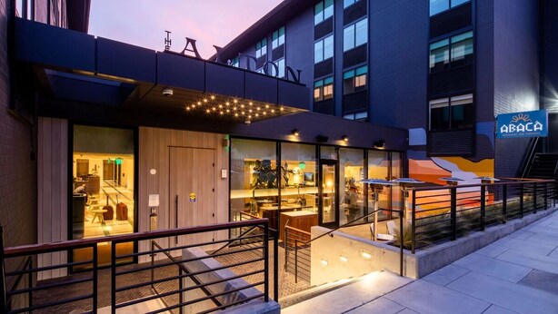 A modern hotel exterior with a glass facade, outdoor seating area, and a staircase leading to the entrance. - Comfortable Room w/ Access to Michelin Guide Dining, Near Fort Mason & Alcatraz! (San Francisco)