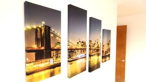 A multi-panel artwork depicting a nighttime cityscape with a bridge and illuminated buildings.