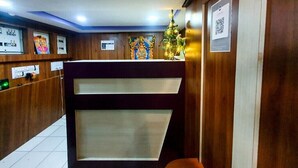 A reception area with a wooden interior, a reception desk, and a decorative Christmas tree. - Cholas Castle inn (Tiruchirappalli)