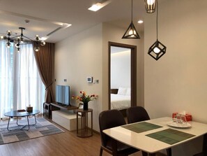 Een hotelkamer met een eethoek, een televisie, een bed en een grote spiegel.