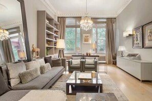 Un salon moderne comprenant un canapé, une table basse et un coin repas avec des chaises.