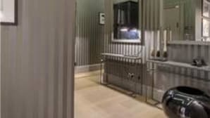 Un bagno moderno con uno specchio grande, un mobile lavabo e una vasca.