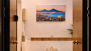 Un espace d’accueil agrémenté d’une photographie de paysage encadrée, d’un comptoir de réception et d’une lettre « A » décorative fixée au mur.