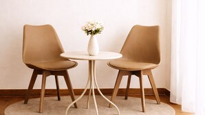 A room with a round table, two chairs, a wall clock, and a vase with flowers. - Antela47 Sleep&Stay Naples (Naples)