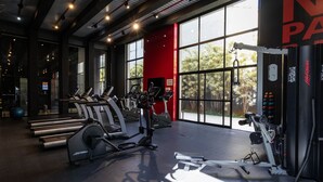 Un gimnasio con cintas de correr, elípticas y máquinas de pesas.
