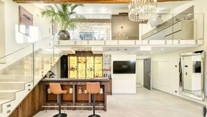 A modern interior with a bar area, glass railings, and a chandelier. - Luxury duplex in the heart of Old Antibes (Antibes)
