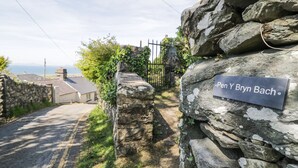 A stone wall with a sign reading "Pen Y Bryn Bach". - Pen Y Bryn Bach (Harlech)