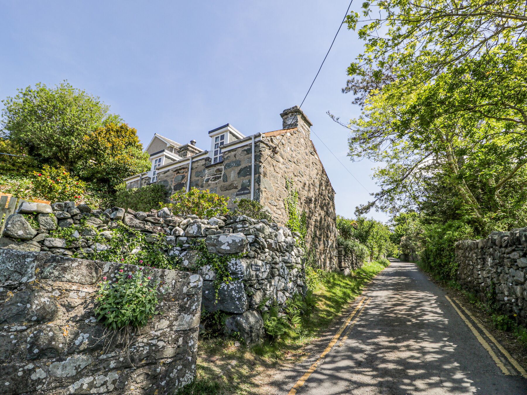 Un edificio de piedra con un muro de piedra y una calle en primer plano.