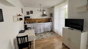 Een knus woongedeelte met een kitchenette, een eethoek en een televisie.