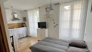 Een slaapkamer met een bed, televisie, bureau en stoel.