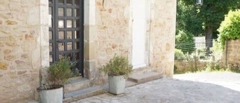 Experience the charm of a traditional accommodation in this historic stone building with a rustic door and quaint setting.