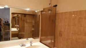 A modern bathroom with a glass-enclosed shower, a large mirror, and a white sink. - Apartment in the port of Hyères (Hyères)